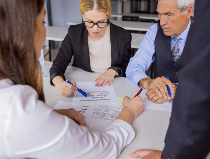 grupo-de-hombres-de-negocios-que-discuten-el-plan-empresarial-en-la-tabla-en-la-oficina